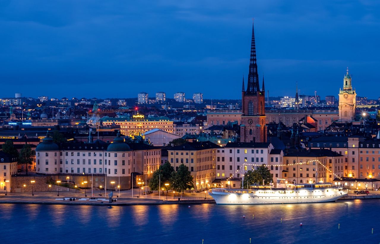 city, cityscape, waterfront, illuminated, ship, architecture, skyline, historic center, church, steeple, water, sea, night, evening, twilight, lights, mirroring, stockholm, sweden, scandinavia