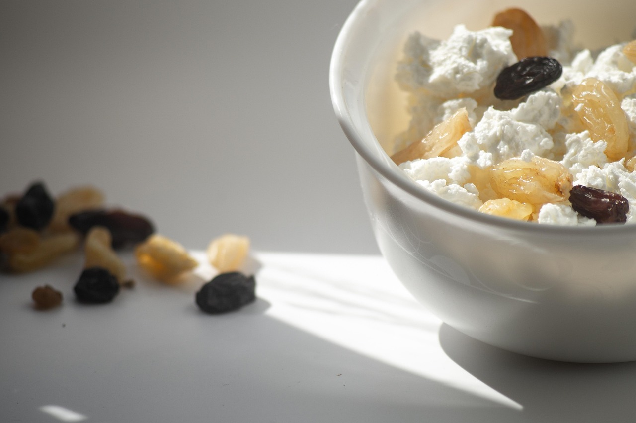 cottage cheese, raisin, plate, a bowl, food