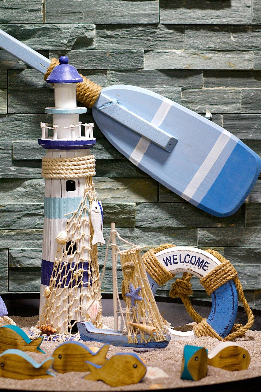 lighthouse, lifebuoy, paddle, fishes, sand