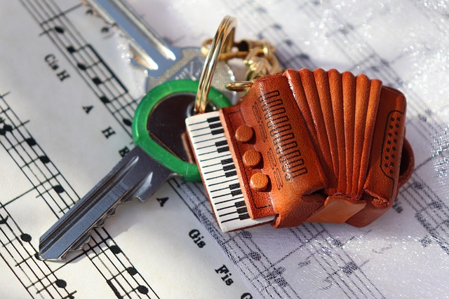 accordion, keychain, music sheet, musical notes, keys, leather keychain, mini accordion, instrument keychain, music lover, close-up, treble clef, harmony, vintage, melody, accordion charm, handcrafted, accessories, music theme, pocket keys, detail, realistic, decorative item, inspiration, folk instrument, keyboard accordion