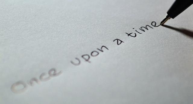 Image of a hand writing 'Once upon a time' on a paper, symbolizing the beginning of a story or an introduction.